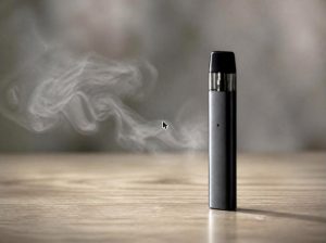 Cigarrillo electrónico sobre una mesa, símbolo de los riesgos del vapeo en adolescentes